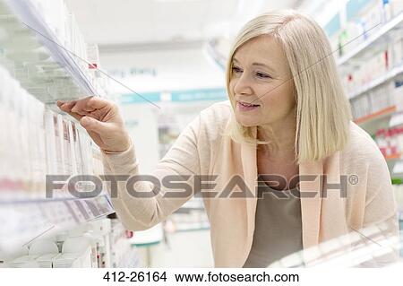 Customer reaching for box on shelf in pharmacy View Large Photo Image Picture - Customer reaching for box on shelf in pharmacy. Fotosearch