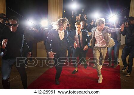 Enthusiastic celebrities arriving and running from paparazzi at red carpet event View Large Photo Image Stock Image - Enthusiastic celebrities arriving and running from paparazzi at red carpet event. Fotosearch