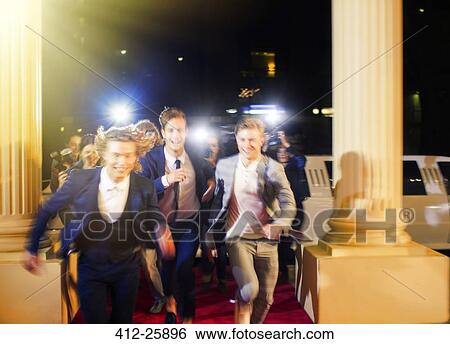Enthusiastic celebrities arriving and running from paparazzi photographers at red carpet event View Large Photo Image Stock Photograph - Enthusiastic celebrities arriving and running from paparazzi photographers at red carpet event. Fotosearch