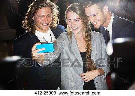 Fan taking selfie with celebrities at event View Large Photo Image Stock Image - Fan taking selfie with celebrities at event. Fotosearch