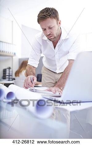 Focused architect drafting blueprint in office View Large Photo Image Stock Image - Focused architect drafting blueprint in office. Fotosearch