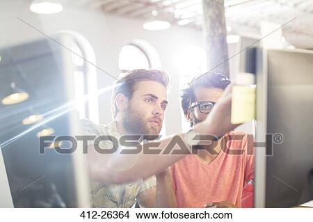 Focused casual businessmen working at computer in sunny office View Large Photo Image Picture - Focused casual businessmen working at computer in sunny office. Fotosearch