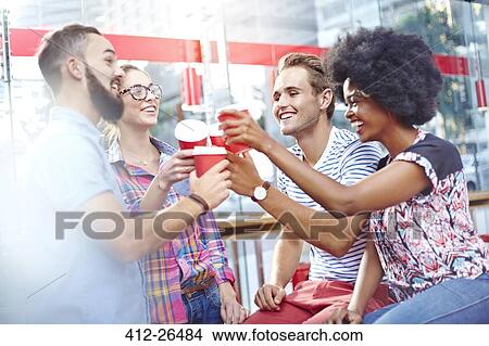 Friends toasting coffee cups in cafe View Large Photo Image Picture - Friends toasting coffee cups in cafe. Fotosearch