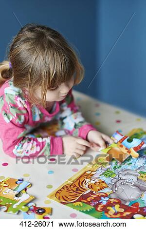 Girl assembling jigsaw puzzle View Large Photo Image Stock Image - Girl assembling jigsaw puzzle. Fotosearch
