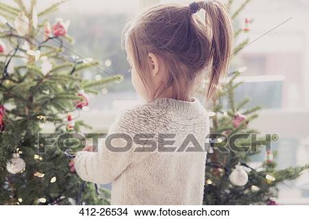 Girl decorating Christmas tree View Large Photo Image Picture - Girl decorating Christmas tree. Fotosearch