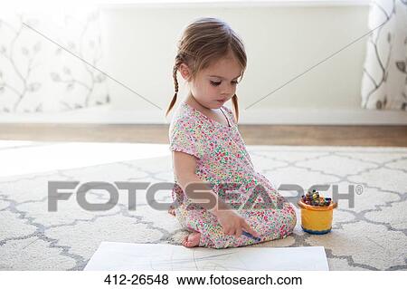 Stock Photo - Girl in dress drawing with crayons. Fotosearch