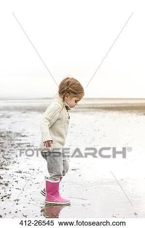 Girl in pink rain boots playing in water on beach View Large Photo Image Stock Photography - Girl in pink rain boots playing in water on beach. Fotosearch
