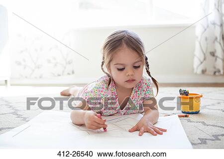 Stock Image - Girl on floor drawing with crayons. Fotosearch