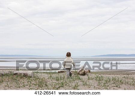 Girl running toward ocean on beach View Large Photo Image Stock Image - Girl running toward ocean on beach. Fotosearch