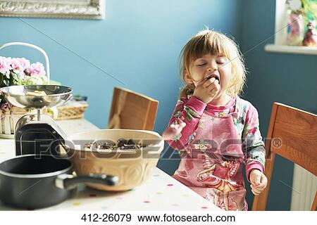 Girl tasting baking ingredients in kitchen View Large Photo Image Stock Photo - Girl tasting baking ingredients in kitchen. Fotosearch