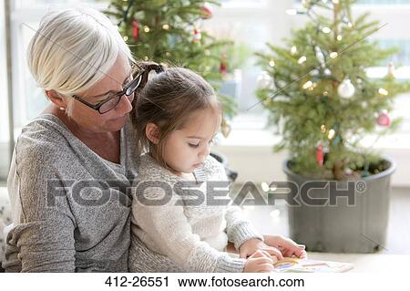 Grandmother watching granddaughter drawing in front of Christmas trees View Large Photo Image Stock Image - Grandmother watching granddaughter drawing in front of Christmas trees. Fotosearch