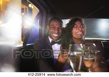 Laughing celebrity couple drinking champagne inside limousine at red carpet event View Large Photo Image Picture - Laughing celebrity couple drinking champagne inside limousine at red carpet event. Fotosearch
