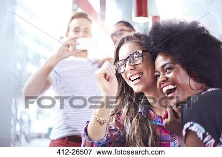Laughing friends hanging out View Large Photo Image Stock Photo - Laughing friends hanging out. Fotosearch