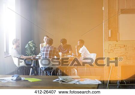 Lens flare over creative business people meeting at office table View Large Photo Image Stock Photo - Lens flare over creative business people meeting at office table. Fotosearch