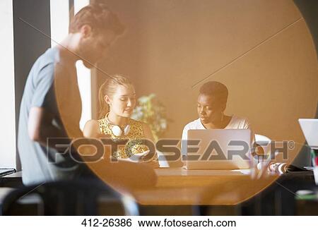 Lens flare over creative business people working in office View Large Photo Image Stock Photograph - Lens flare over creative business people working in office. Fotosearch