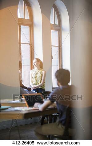 Lens flare over smiling businesswomen talking in office window View Large Photo Image Stock Photography - Lens flare over smiling businesswomen talking in office window. Fotosearch