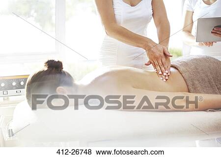 Stock Photo - Masseuse massaging woman’s back. Fotosearch