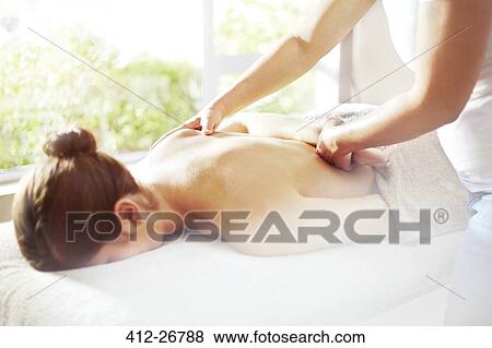 Stock Photo - Masseuse massaging woman’s back. Fotosearch