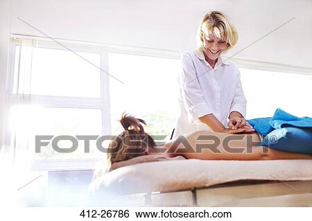 Masseuse massaging woman’s back View Large Photo Image Stock Photograph - Masseuse massaging woman’s back. Fotosearch