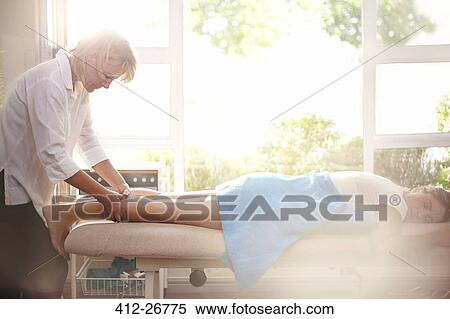 Masseuse massaging woman’s legs View Large Photo Image Stock Photography - Masseuse massaging woman’s legs. Fotosearch