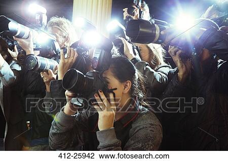 Stock Image - Paparazzi photographers photographing event. Fotosearch