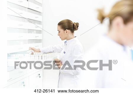 Stock Image - Pharmacist filling prescription in pharmacy. Fotosearch