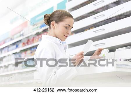 Stock Image - Pharmacist filling prescription in pharmacy. Fotosearch