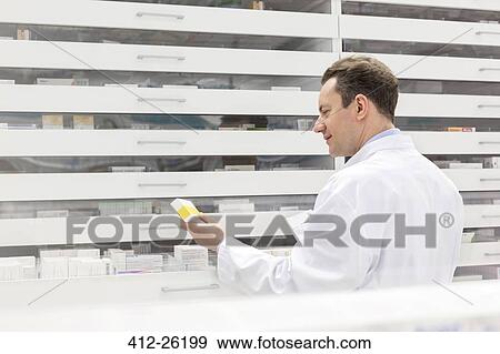 Pharmacist filling prescription in pharmacy View Large Photo Image Stock Photo - Pharmacist filling prescription in pharmacy. Fotosearch