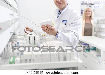 Pharmacist filling prescription in pharmacy View Large Photo Image Stock Photography - Pharmacist filling prescription in pharmacy. Fotosearch