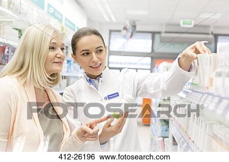 Pharmacist recommending products to customer in pharmacy View Large Photo Image Stock Photograph - Pharmacist recommending products to customer in pharmacy. Fotosearch