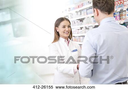 Pharmacist talking to customer in pharmacy View Large Photo Image Stock Photography - Pharmacist talking to customer in pharmacy. Fotosearch