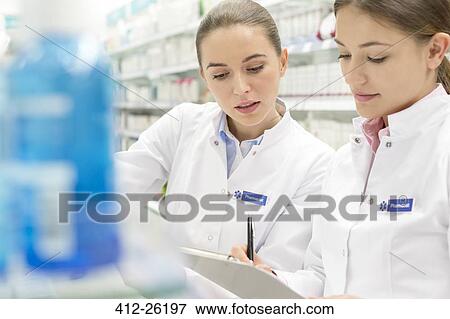 Stock Photo - Pharmacists taking inventory in pharmacy. Fotosearch