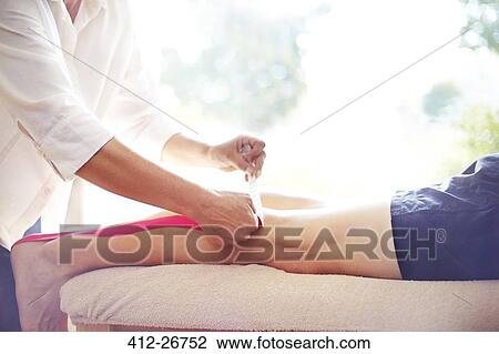 Physical therapist applying kinesiology tape to man’s leg View Large Photo Image Stock Image - Physical therapist applying kinesiology tape to man’s leg. Fotosearch