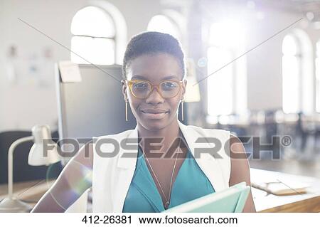 Stock Image - Portrait confident businesswoman wearing eyeglasses in office. Fotosearch