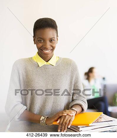Portrait confident businesswoman with laptop and magazines in office View Large Photo Image Stock Photo - Portrait confident businesswoman with laptop and magazines in office. Fotosearch