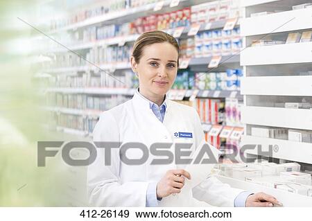 Portrait of confident pharmacist holding prescription in pharmacy View Large Photo Image Stock Photo - Portrait of confident pharmacist holding prescription in pharmacy. Fotosearch
