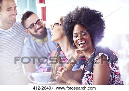 Stock Photo - Portrait of laughing woman hanging out with friends in cafe. Fotosearch