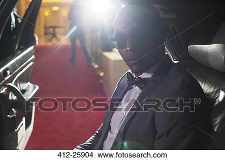 Portrait of serious celebrity in sunglasses inside limousine arriving at red carpet event View Large Photo Image Picture - Portrait of serious celebrity in sunglasses inside limousine arriving at red carpet event. Fotosearch