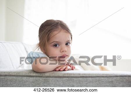 Portrait of serious girl on sofa View Large Photo Image Stock Photograph - Portrait of serious girl on sofa. Fotosearch