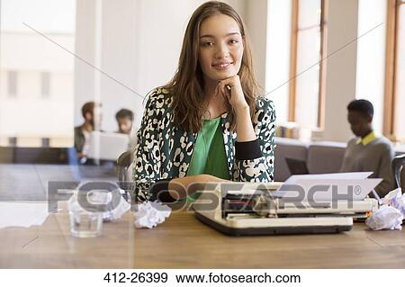 Stock Photo - Portrait smiling creative writer at typewriter in office. Fotosearch