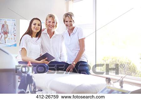 Stock Photo - Portrait smiling physical therapists in examination room. Fotosearch