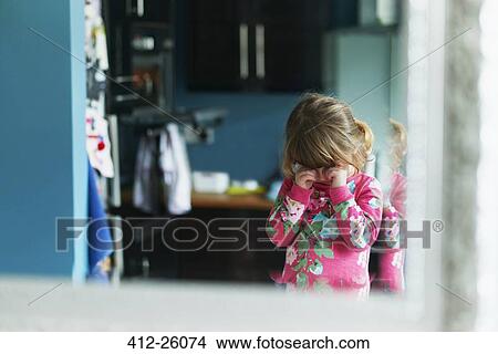 Picture - Reflection of upset girl rubbing eyes in mirror. Fotosearch