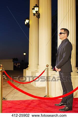 Serious bodyguard in sunglasses protecting red carpet at event View Large Photo Image Stock Image - Serious bodyguard in sunglasses protecting red carpet at event. Fotosearch