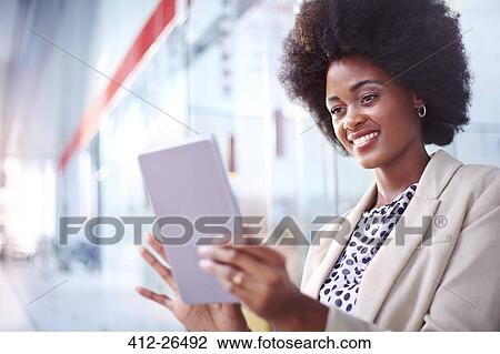 Stock Image - Smiling businesswoman using digital tablet. Fotosearch