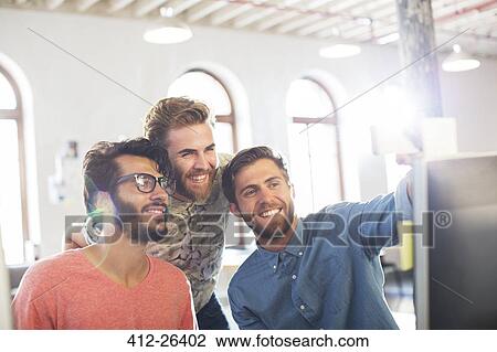 Smiling casual businessmen working at computer in office View Large Photo Image Stock Image - Smiling casual businessmen working at computer in office. Fotosearch