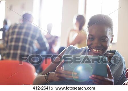Stock Photography - Smiling casual businesswoman using digital tablet in office. Fotosearch