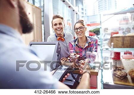 Smiling couple paying worker at cafe counter View Large Photo Image Stock Photograph - Smiling couple paying worker at cafe counter. Fotosearch