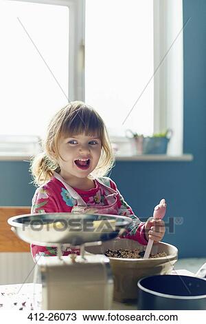 Smiling girl baking with mixing bowl in kitchen View Large Photo Image Stock Image - Smiling girl baking with mixing bowl in kitchen. Fotosearch