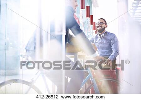 Smiling man on bicycle in cafe View Large Photo Image Stock Image - Smiling man on bicycle in cafe. Fotosearch