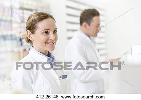 Stock Photograph - Smiling pharmacist in pharmacy. Fotosearch